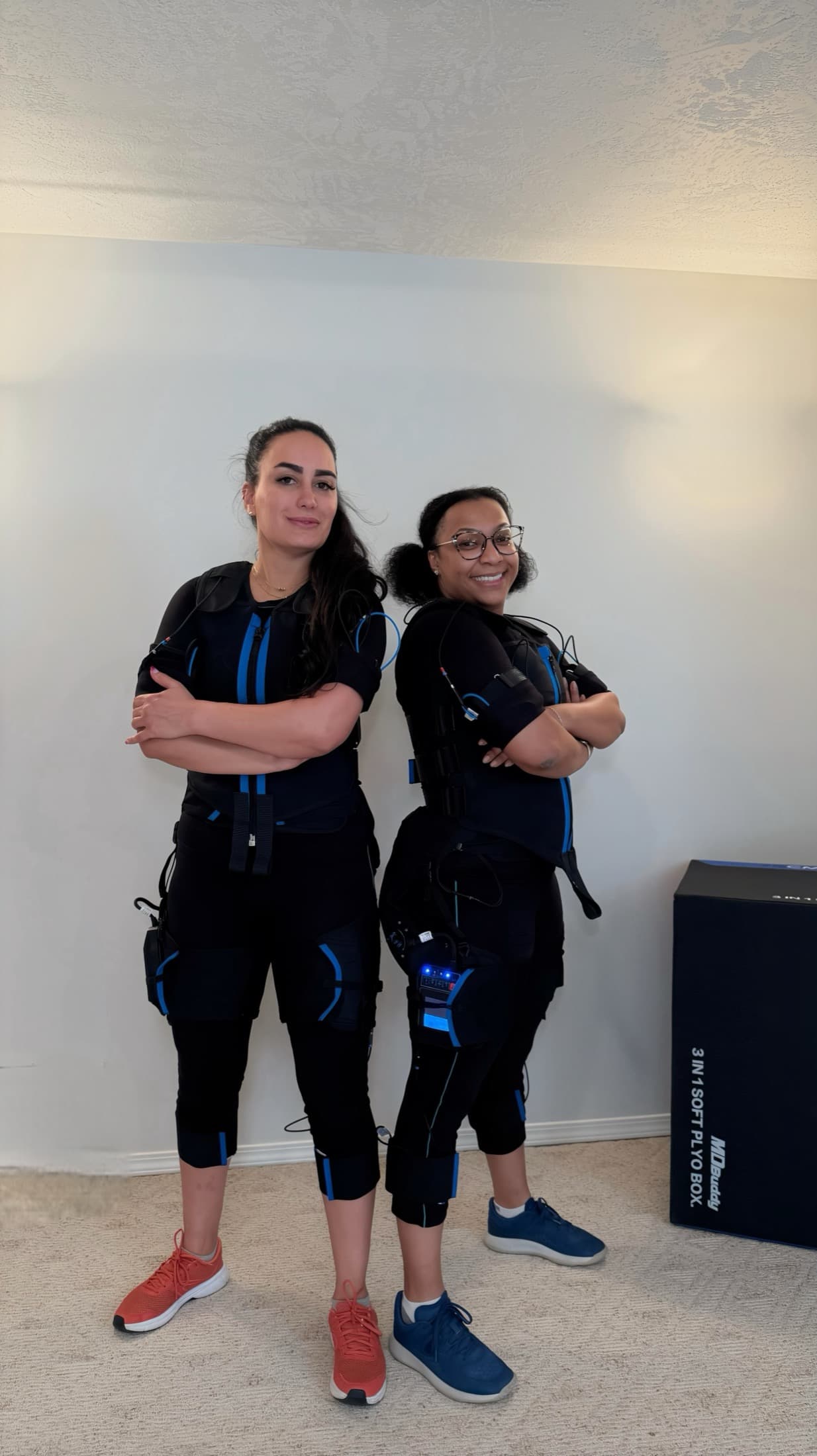 Two clients wearing EMS suits before a guided partner EMS session at MZ Fit Club.